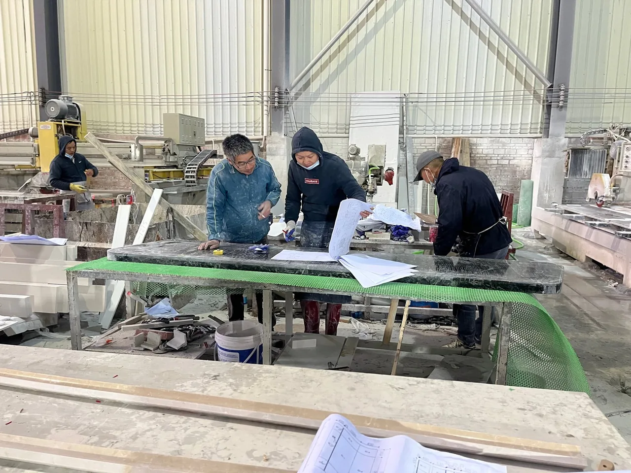 Stone production team reviewing technical details at a workshop